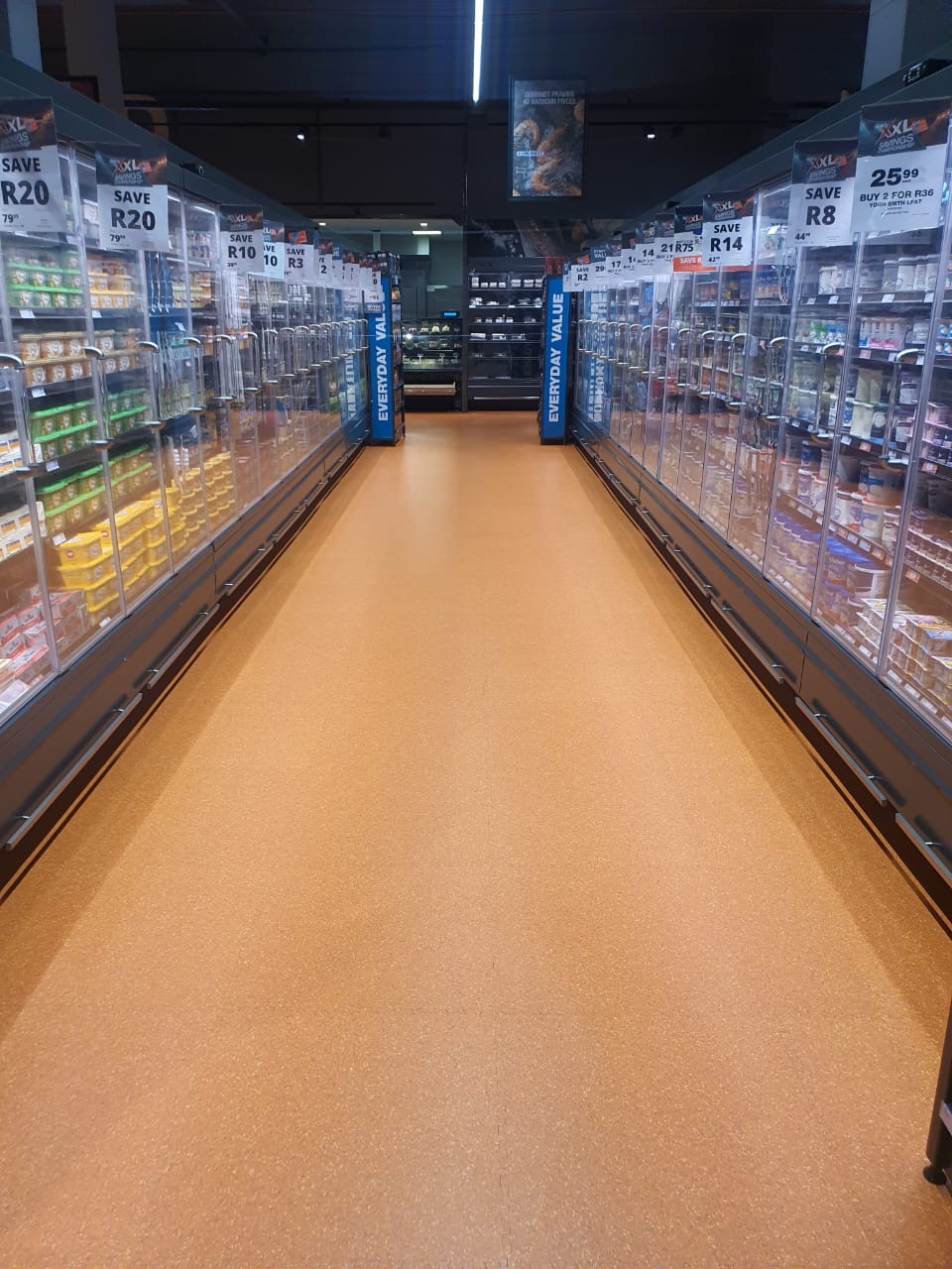 Supermarket refrigerated aisle with orange quartz flooring