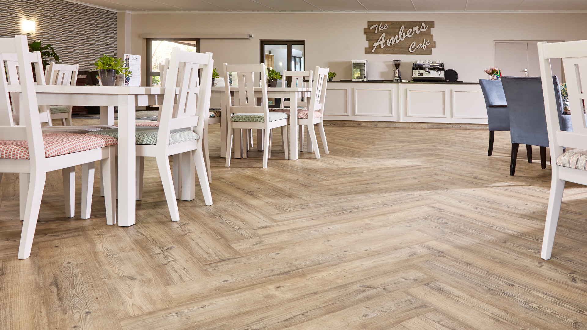 Cafe dining area with herringbone wood-look vinyl flooring