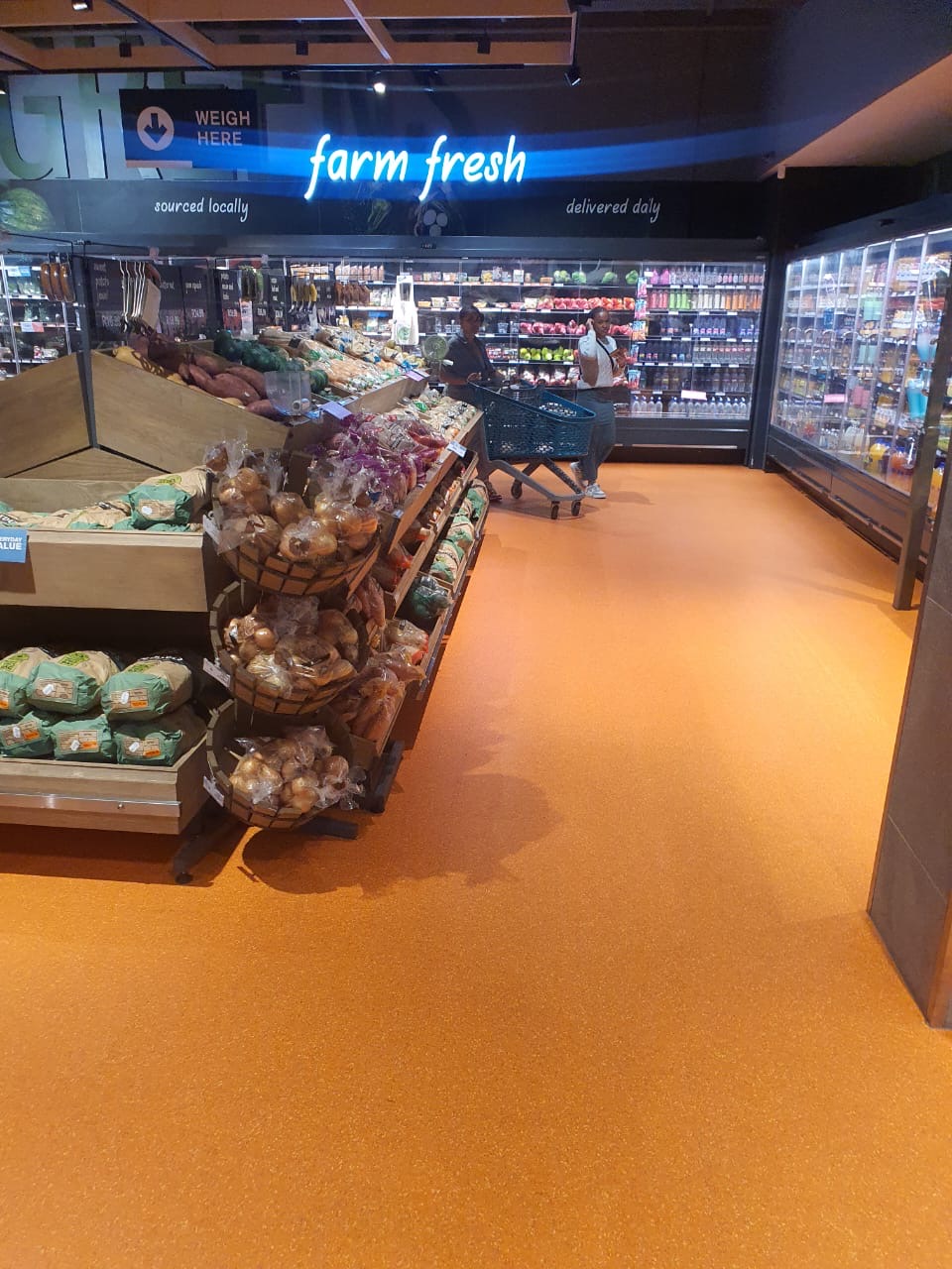 Supermarket fresh produce aisle with orange quartz flooring